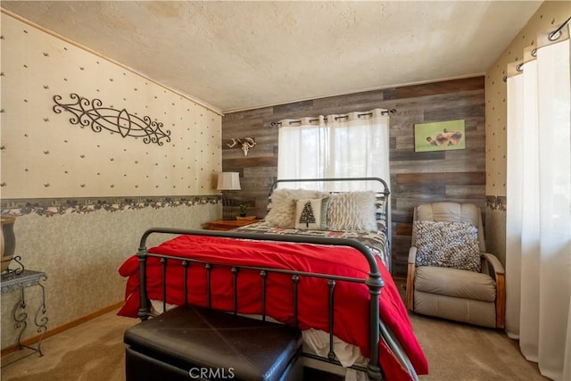 bedroom with a textured ceiling, carpet flooring, and wood walls