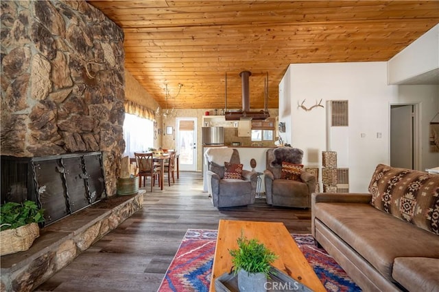 living room with lofted ceiling, hardwood / wood-style flooring, a stone fireplace, and wooden ceiling