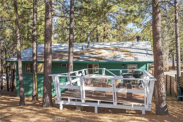 rear view of property featuring a wooden deck