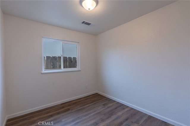 unfurnished room with dark wood-type flooring