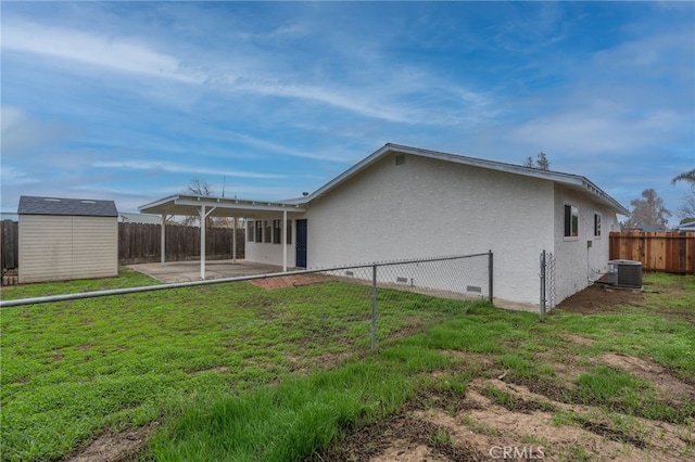 back of house with a lawn, cooling unit, a storage shed, and a patio