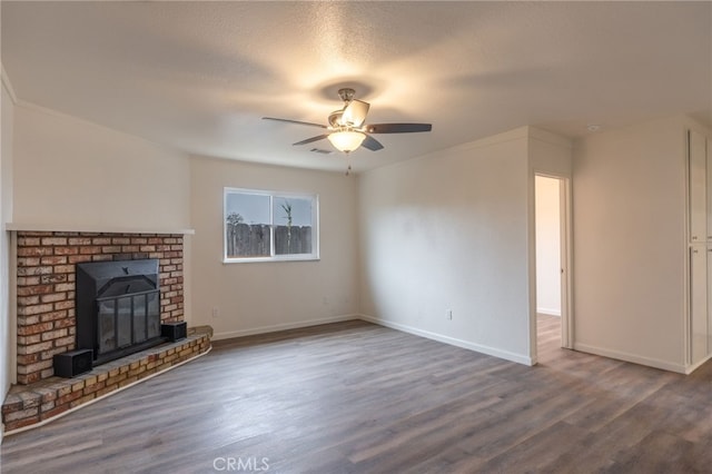 unfurnished living room with ceiling fan, dark wood-type flooring, a textured ceiling, and a fireplace