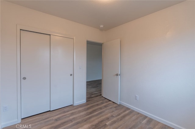 unfurnished bedroom featuring a closet and hardwood / wood-style floors