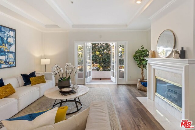 living room with dark hardwood / wood-style floors, ornamental molding, and a premium fireplace