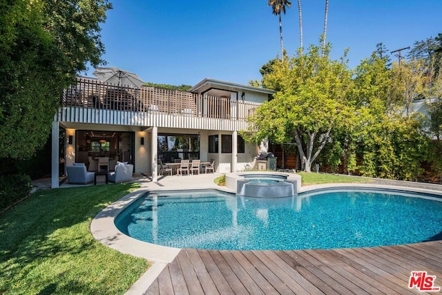 rear view of property with a pool with hot tub and an outdoor hangout area