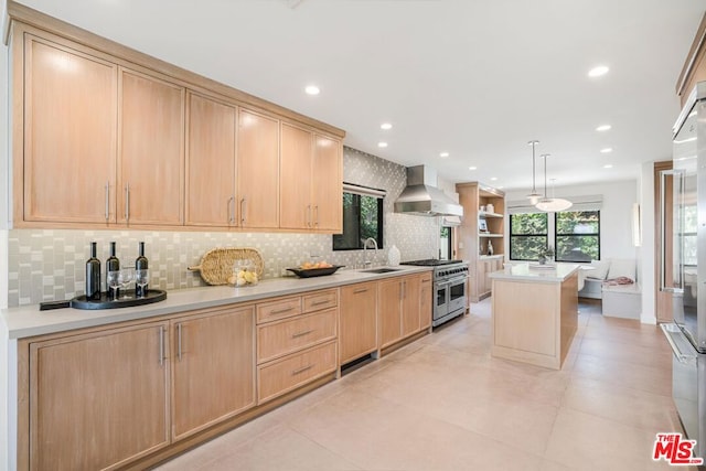 kitchen with sink, double oven range, wall chimney range hood, and light brown cabinetry