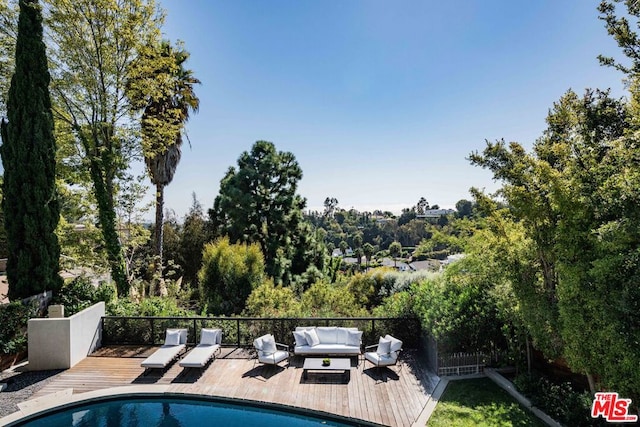 view of swimming pool featuring a wooden deck and outdoor lounge area