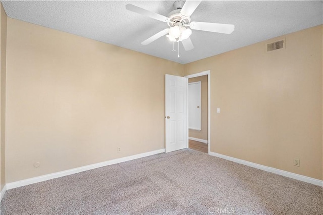 spare room with ceiling fan, carpet flooring, and a textured ceiling