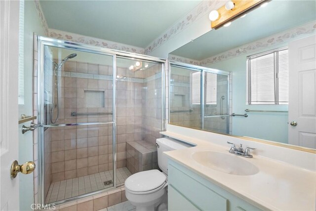 bathroom featuring a shower with shower door, tile patterned floors, toilet, and vanity