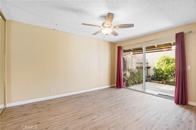 spare room featuring light wood-type flooring, a textured ceiling, and ceiling fan