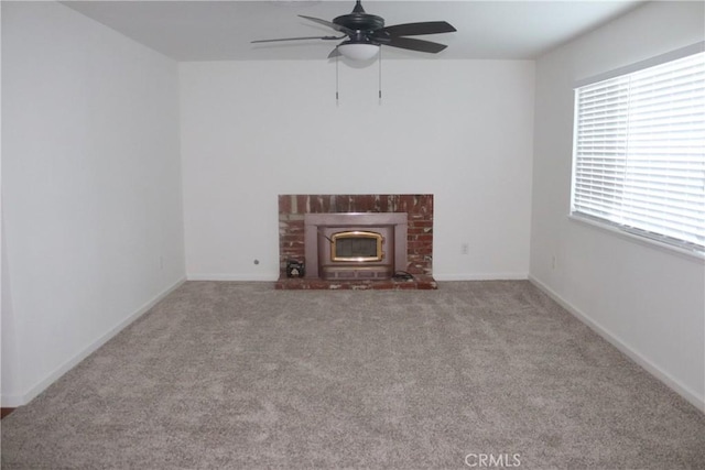 unfurnished living room with a brick fireplace, light carpet, and ceiling fan