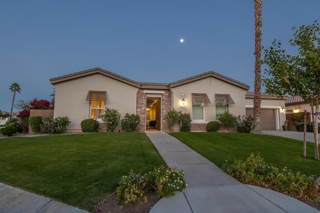 view of front of property featuring a lawn and a garage