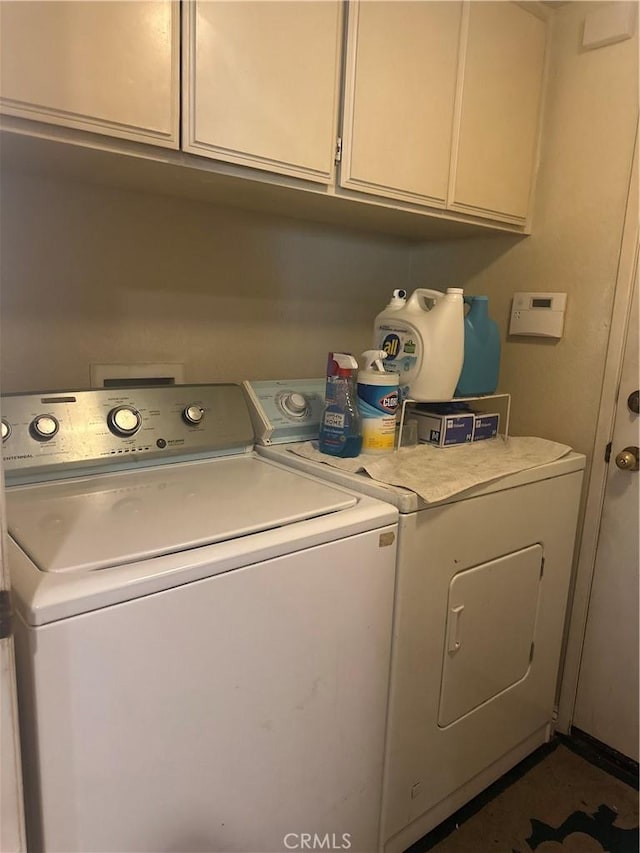 laundry room with washer and clothes dryer and cabinets