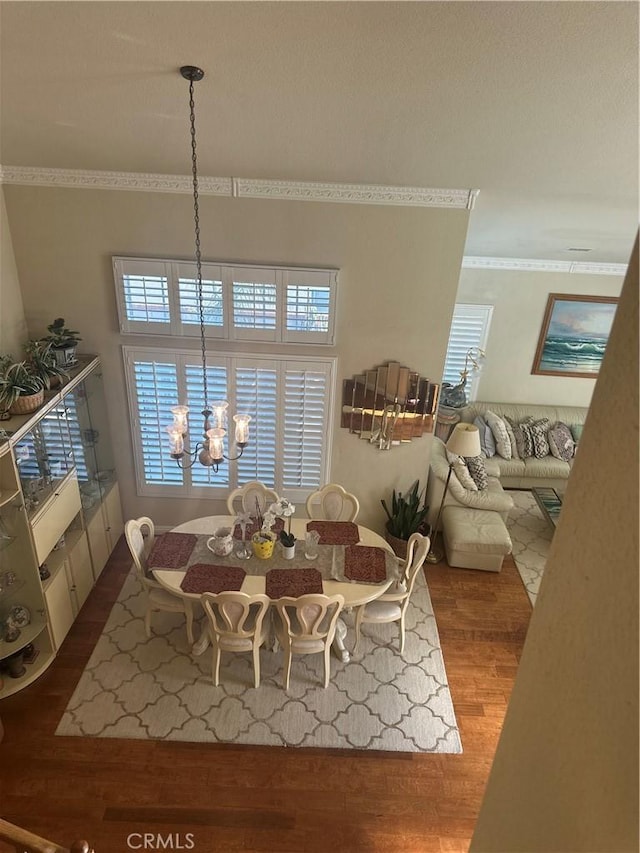 dining space featuring hardwood / wood-style floors and an inviting chandelier