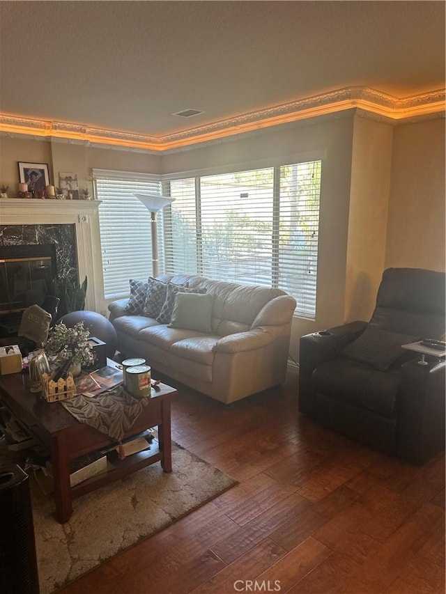 living room featuring a fireplace, crown molding, and hardwood / wood-style floors