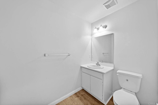 bathroom featuring hardwood / wood-style flooring, toilet, and vanity