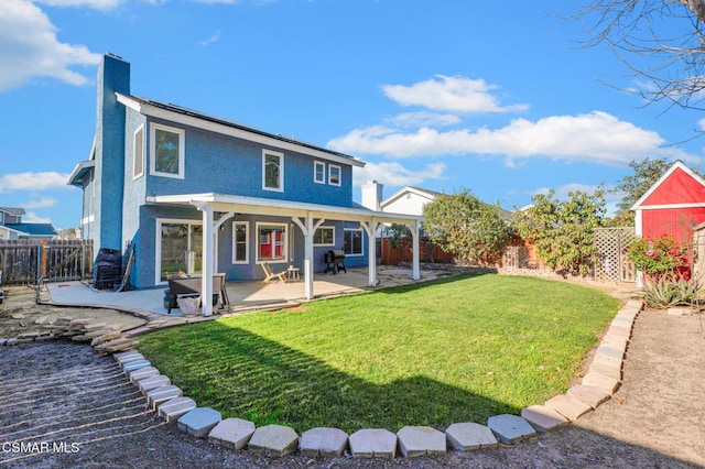 rear view of house with a patio area and a yard