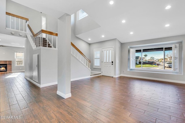 unfurnished living room featuring a wealth of natural light, a fireplace, and a towering ceiling