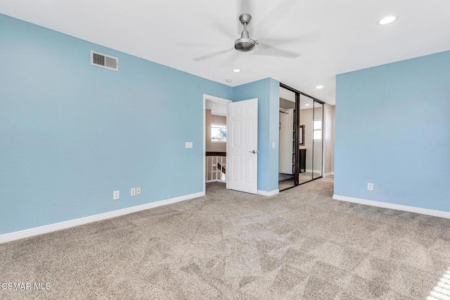 unfurnished bedroom featuring ceiling fan, a closet, carpet, and multiple windows