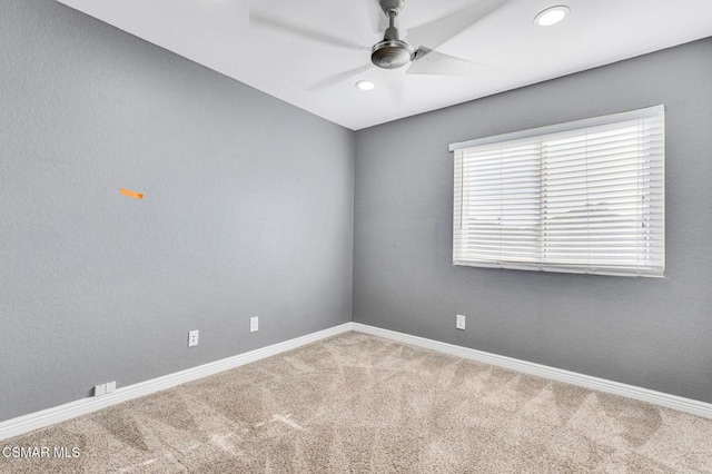 carpeted spare room featuring ceiling fan