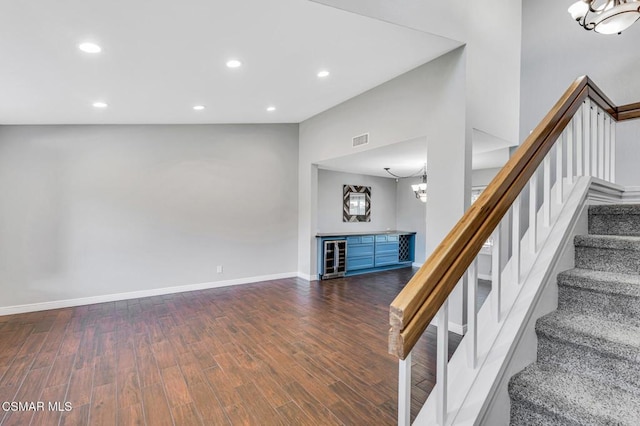 stairway with wood-type flooring, bar area, and beverage cooler