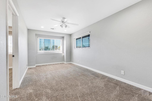 spare room with ceiling fan and carpet