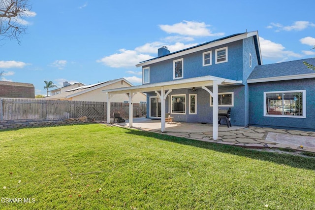 rear view of house with a lawn and a patio