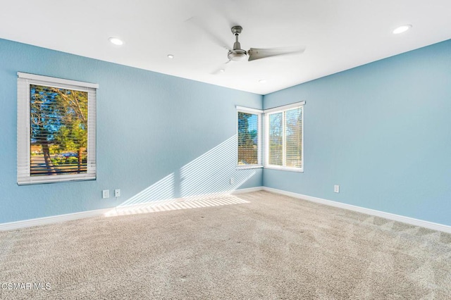 carpeted spare room featuring ceiling fan