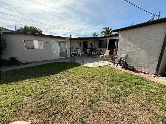 back of property featuring a yard and a patio