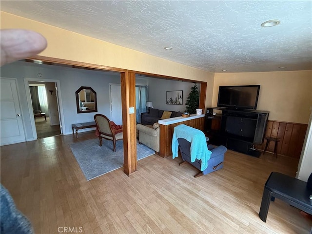 living room with light hardwood / wood-style floors and a textured ceiling