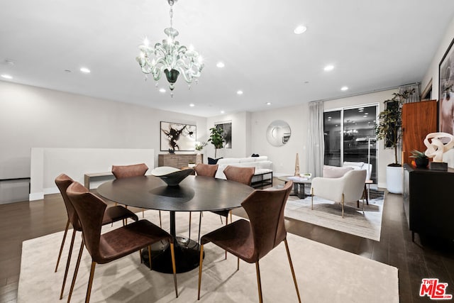 dining space with dark wood-type flooring and an inviting chandelier