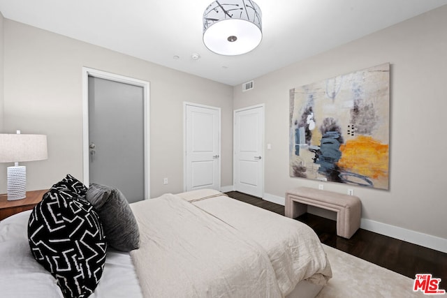 bedroom with dark wood-type flooring