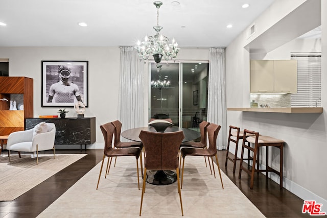 dining space featuring hardwood / wood-style floors and an inviting chandelier