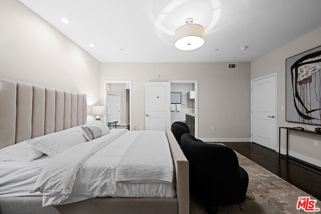 bedroom featuring dark hardwood / wood-style flooring and connected bathroom