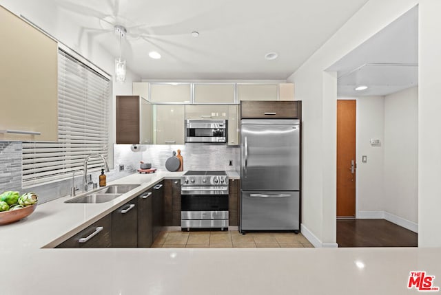 kitchen with light tile patterned flooring, sink, appliances with stainless steel finishes, white cabinets, and dark brown cabinets