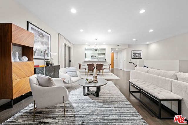 living room featuring dark wood-type flooring and an inviting chandelier