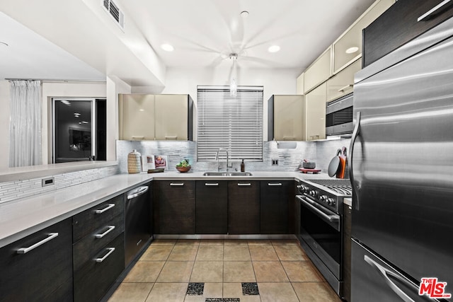 kitchen with light tile patterned floors, ceiling fan, appliances with stainless steel finishes, tasteful backsplash, and sink