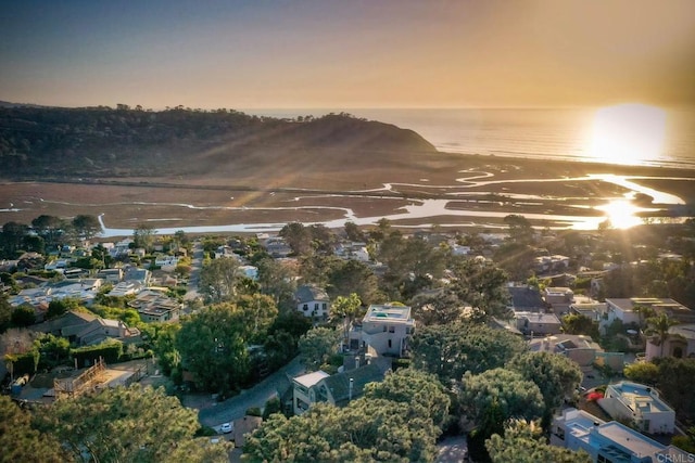 aerial view at dusk featuring a water view