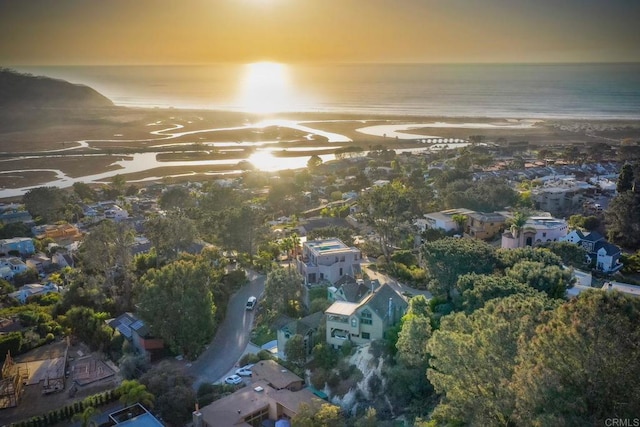 aerial view at dusk featuring a water view