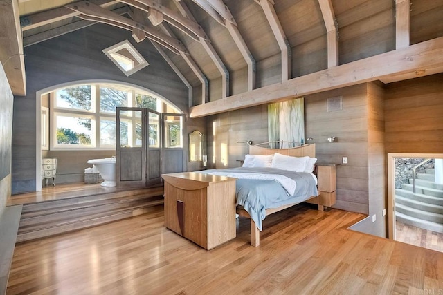 bedroom featuring high vaulted ceiling, wood-type flooring, beamed ceiling, and wooden walls