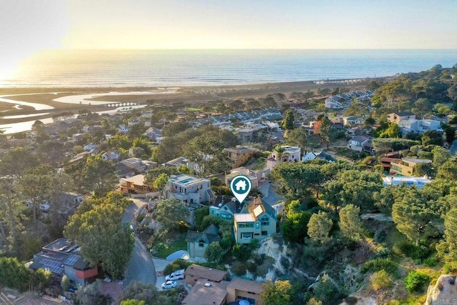 aerial view at dusk with a water view and a view of the beach