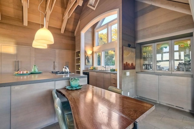 tiled dining area featuring high vaulted ceiling, beam ceiling, and wooden walls