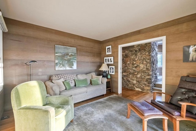 living room with hardwood / wood-style floors and wooden walls