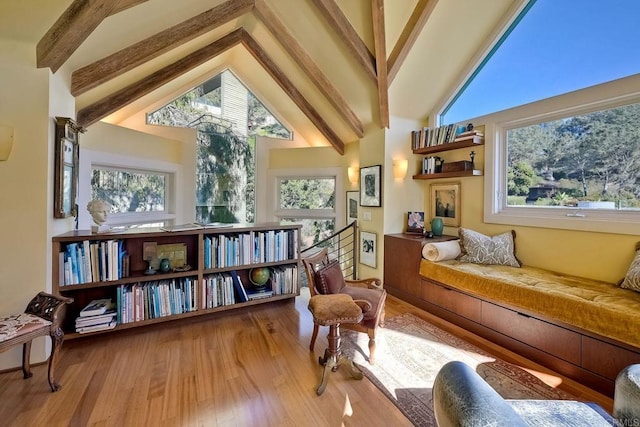 living area with vaulted ceiling with beams and hardwood / wood-style floors