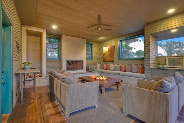 living room featuring ceiling fan, wood-type flooring, and wood ceiling