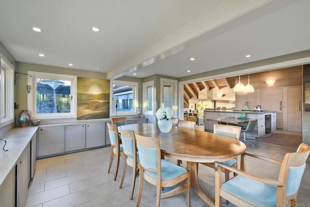 dining space with a wealth of natural light, light tile patterned floors, and beamed ceiling