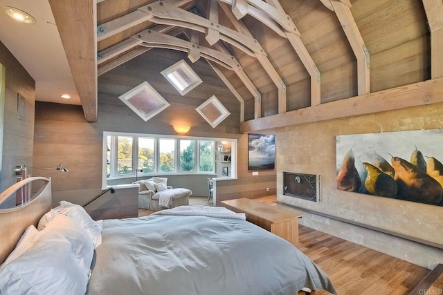 bedroom with vaulted ceiling with beams, wood walls, and hardwood / wood-style floors