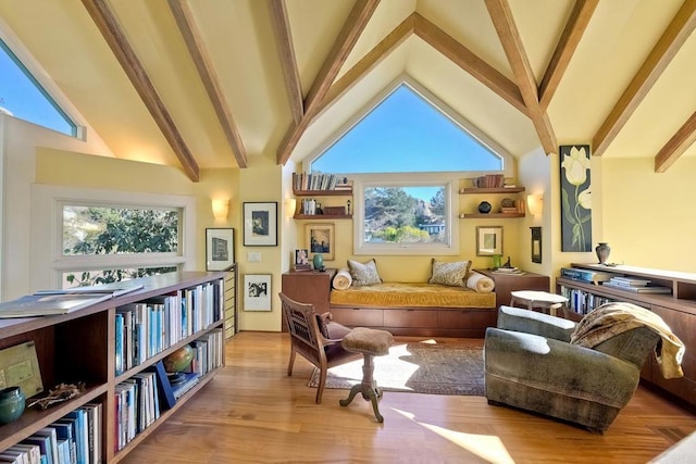 living area with high vaulted ceiling, beamed ceiling, and light hardwood / wood-style flooring