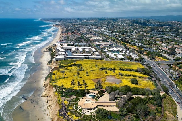 birds eye view of property featuring a water view and a beach view