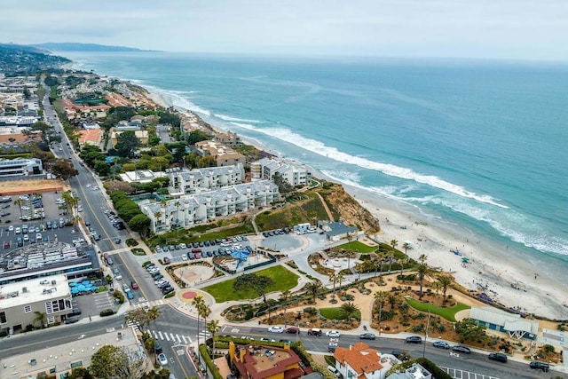 birds eye view of property with a water view and a beach view